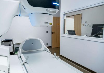 Appareil de radiologie numérique avec bras articulé et table d’examen dans une salle médicale moderne
